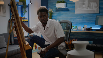 Young black artist drawing and getting inspiration from vase design on table. African american person sitting in workshop studio creating fine art masterpiece as professional hobby