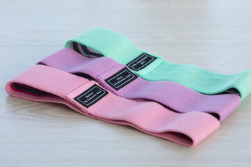 A set of colourful rubber bands for fitness on a grey background. sports concept. Top view, flat lay, copy space.