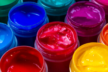 Selective focus open jars with gouache of different colors close-up. Hobby - painting