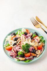 Seafood with vegetables in a plate on the table.