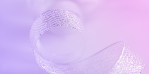 Abstract beautiful macro. Silver ribbon on a delicate purple background. Selective soft focus. Banner.