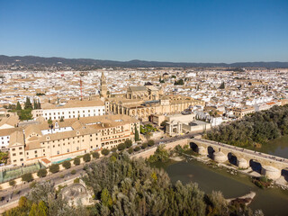 Fototapeta na wymiar Dramatic aerial view of the famous Roman bridge above the Guadalquivir river along Cordoba old town in Andalusia in southern Spain on a sunny day