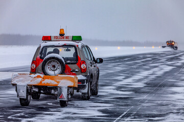 Snow plows on the runway in a snowstorm