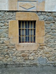 blue barred window in stone house