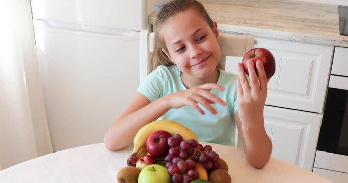the child eats fruits with pleasure. The girl eats healthy food. the concept of children's health