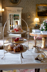 A rack of delicious English teashop cakes and sandwiches served for afternoon tea.