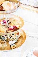 A rack of delicious English teashop cakes and sandwiches served for afternoon tea.