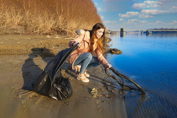 Young volunteer cleaning up the water from trash