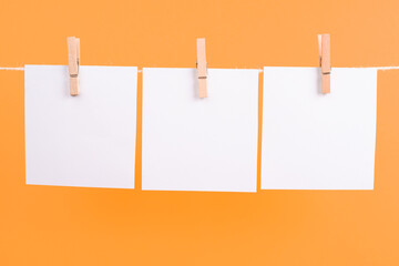 Empty white sheets of paper in a row hanging on a string, copy space for pictures and text, message communication and marketing background