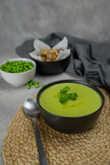 Summer cream soup with green fresh pea shoots.