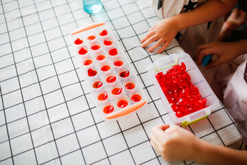 Funny children play with hearts and water at home in the kitchen. Educational classes and...
