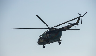 Fototapeta premium The military helicopter against the blue sky