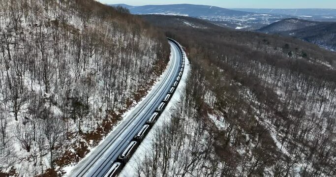 Train transport coal from mines through scenic mountain pass. Cargo freight shipping logistics theme. Beautiful nature.