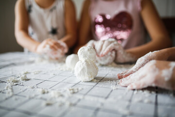 Funny children play with artificial snow at home in the kitchen. Educational classes and experiments with children at home. Sensory development and games at home. Snow from starch and shaving foam