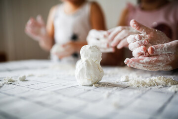 Funny children play with artificial snow at home in the kitchen. Educational classes and experiments with children at home. Sensory development and games at home. Snow from starch and shaving foam