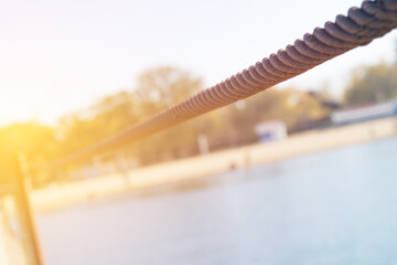 Old rusty cable and anchorage on the sea pier closeup