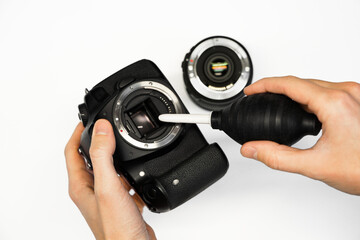 a man cleans the matrix of a reflex camera with an air pear close-up