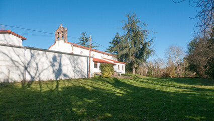 Iglesia rural antigua junto a pradera de hierba verde