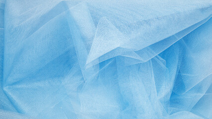 Background crumpled tulle fabric beautiful pastel blue color.