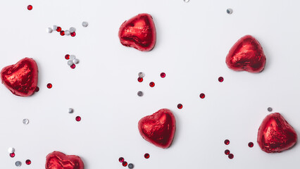 Red foiled chocolate hearts on a white background, chocolate hearts. Valentines day concept