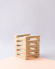 Construction of a tower of wafers in gray peach color. Minimal lay out composition