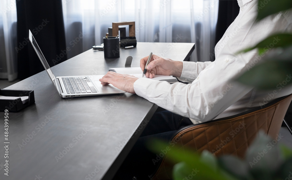Poster businessman hands taking notes in notebook and surfing information on internet or preparing for corp