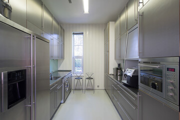 Modern interior of metal kitchen in luxury apartment. Home appliances.