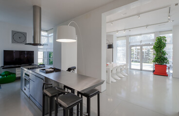 Fototapeta na wymiar Modern white interior of spacious private house. Kitchen dinner room.
