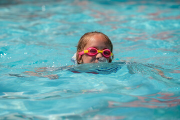 Naklejka premium Happy child girl playing in the sea. Kid having fun in water. Summer vacation and healthy lifestyle concept.