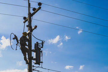 The silhouette of power lineman replacing a transformer and hotline clamp, bail  clamp. Using clamp stick grip all type, wearing personal protective equipmen,
