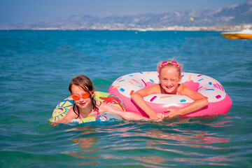 Happy child girls playing in the sea and having fun with water.  Summer vacation and healthy lifestyle concept.