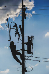 The silhouette of power lineman replacing a transformer and hotline clamp, bail  clamp. Using clamp...
