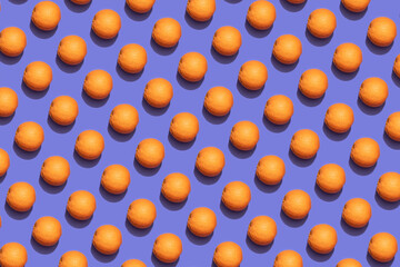 Fruit oranges in checkered pattern on violet background. Violet and orange colors background from...