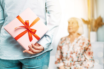 Gift for mother. Young caucasian daughter gives her mom a gift