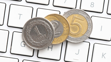 1 zloty, 2 zloty, 5 zloty, a coin of Polish on the computer keyboard. Concept for business.