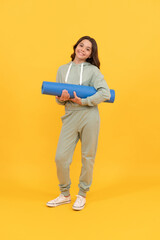 full length of cheerful child in sports suit with fitness mat. fit your body. sport teen girl