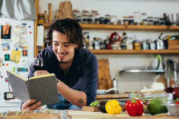 man looking for recipe in cook book in kitchen