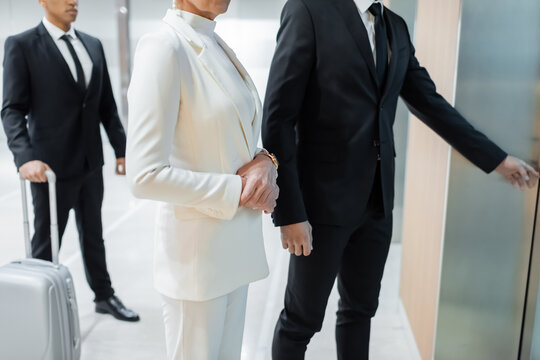 cropped view of interracial bodyguards escorting mature businesswoman in hotel during business trip.