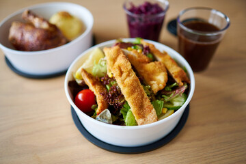 Gesunder Salat zum Mitnehmen in einer Take away Tupperschale mit Putenbruststreifen und Schnitzel