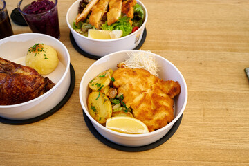 Ente gebraten Schweinebraten Salat zum Mitnehmen in einer Take away Recyclebarer Box tupperschale für zuhause oder das Büro mit kartoffelknödel Blaukraut und Soße von einem bayerischen Restaurant Wirt