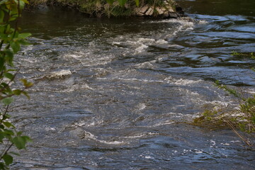 Swirling and bubbling water in a fast flowing river ruhr in germay with strong currents. Swimming in it is dangerous