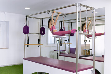 little girl doing pilates studio with machines, cadillac, barrel, reformer