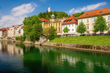 Embankment of Ljubljanica river and old buildings and castle tower in the historical center of Ljubljana, Slovenia