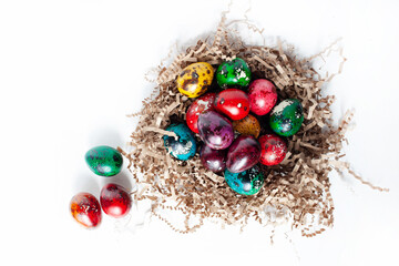 Fototapeta na wymiar traditional Easter decoration. multicolored bright eggs in a nest on a white background