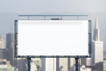 Obraz premium Blank white horizontal billboard on city buildings background at daytime, front view. Mockup, advertising concept