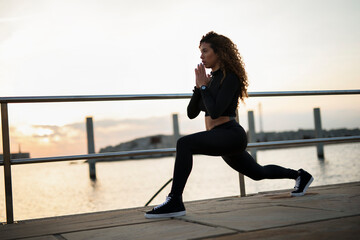 Obraz premium Beautiful young woman training outside. Fit sexy woman doing exercise..