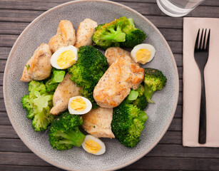 healthy appetizer of chicken pieces with broccoli and quail eggs in bowl for healthy lunch