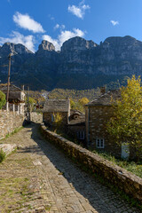 view of traditional architecture  with   stone buildings and background astraka mountain during  fall season in the picturesque village of papigo , zagori Greece