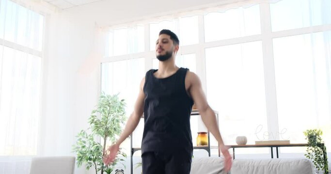 Man doing jumping jack exercise at home
