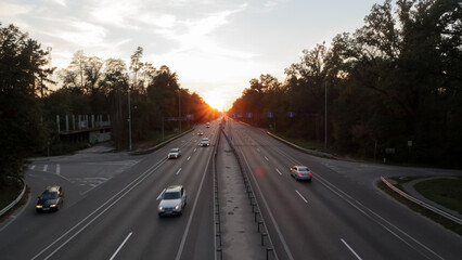 Moving cars on the motorway at sunset time. Highway traffic at sunset with cars. Busy traffic on the freeway, road top view.